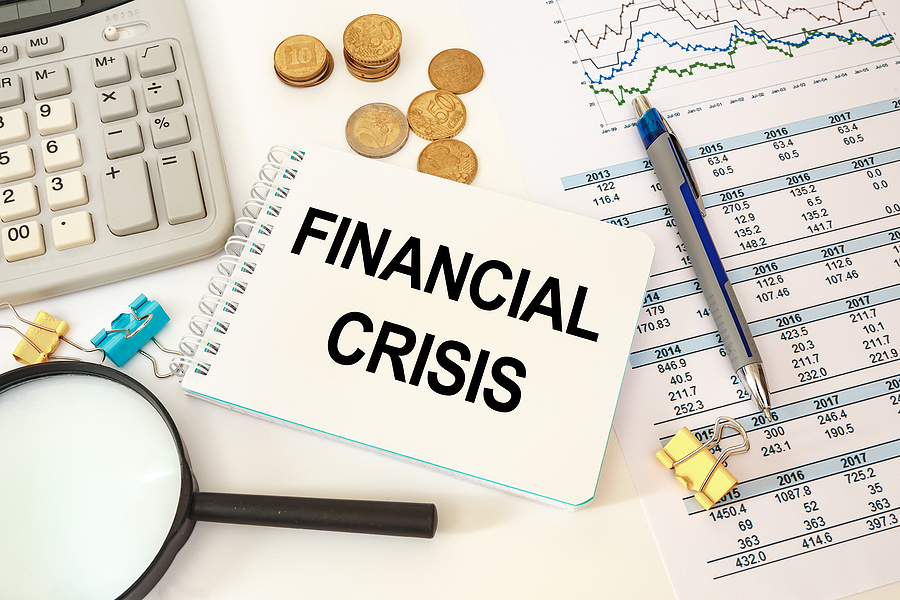 Business concept - workspace office desk and notebook writing FINANCIAL CRISIS Business concept - workspace office desk and notebook writing FINANCIAL CRISIS